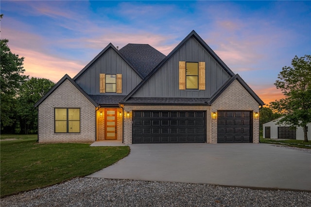 13040 Seba Rd, Centerton, AR 72719 - view of front of home with board and batten siding, a yard, driveway, brick siding, and a garage