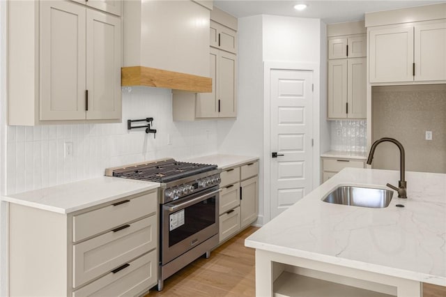 13040 Seba Rd, Centerton, AR 72719 - kitchen featuring high end range, a sink, custom range hood, decorative backsplash, and light stone counters