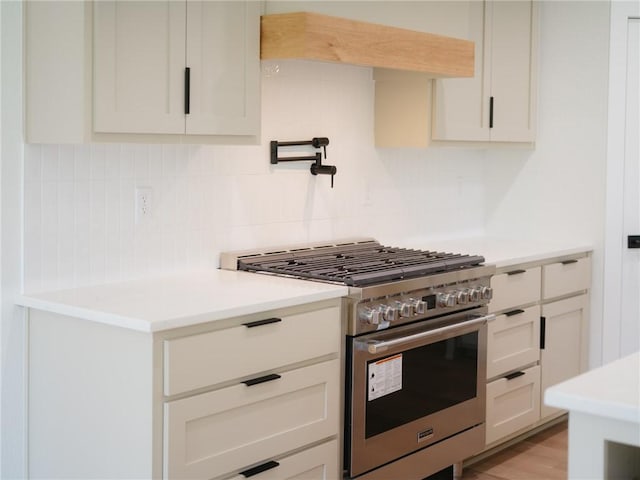 13040 Seba Rd, Centerton, AR 72719 - kitchen featuring high end range, backsplash, light countertops, light wood-style flooring, and white cabinetry