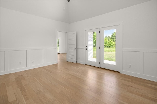13040 Seba Rd, Centerton, AR 72719 - unfurnished room with a decorative wall, light wood finished floors, a towering ceiling, ceiling fan, and a wainscoted wall
