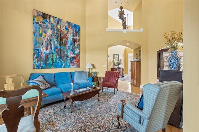 living room featuring baseboards, wood finished floors, and arched walkways
