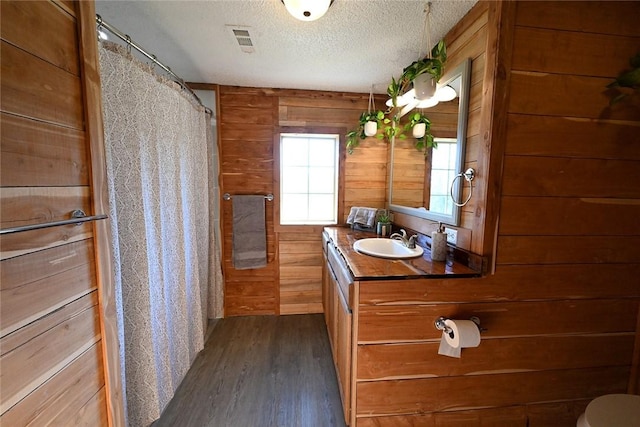 12766 Rocky Hill Rd, Prairie Grove, AR 72753 - full bath with wood finished floors, a textured ceiling, wooden walls, and visible vents