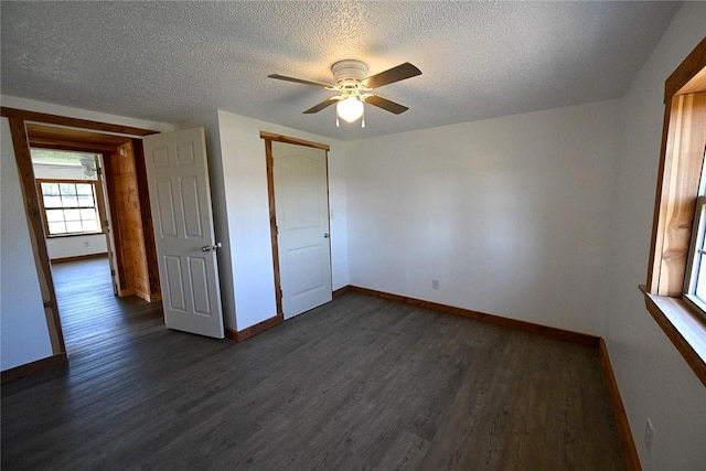 12766 Rocky Hill Rd, Prairie Grove, AR 72753 - unfurnished bedroom with a closet, dark wood-type flooring, baseboards, and a textured ceiling