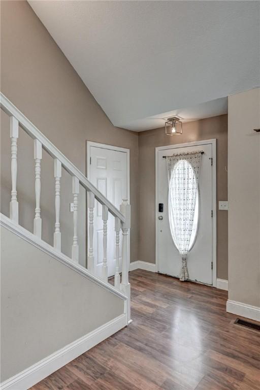 1801 Cash St, Neosho, MO 64850 - entrance foyer with visible vents, baseboards, wood finished floors, and stairs