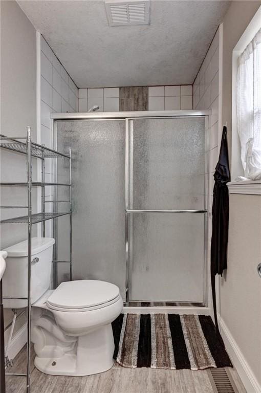 1801 Cash St, Neosho, MO 64850 - full bathroom featuring a shower stall, visible vents, toilet, and wood finished floors