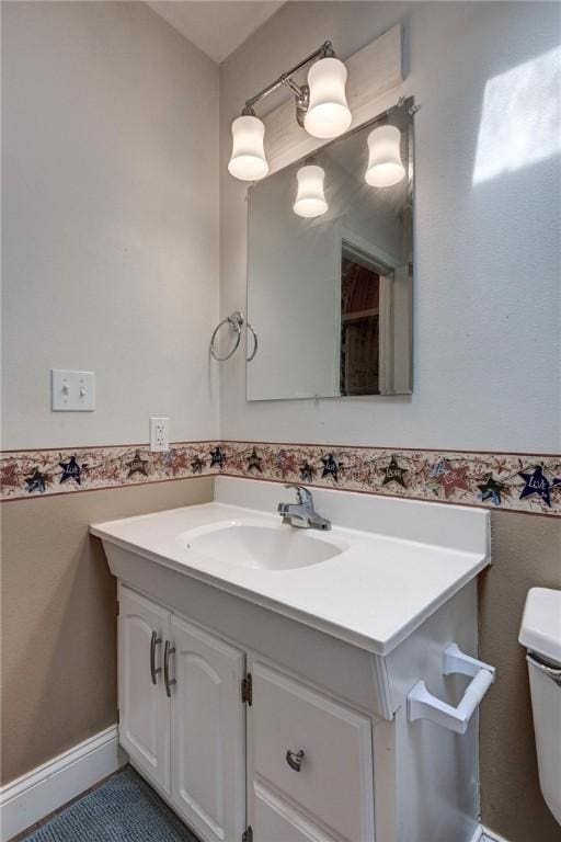 1801 Cash St, Neosho, MO 64850 - bathroom featuring toilet, vanity, and a wainscoted wall
