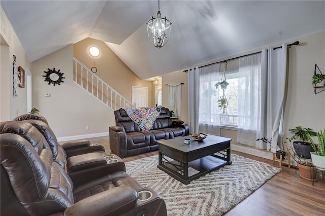 1801 Cash St, Neosho, MO 64850 - living room featuring vaulted ceiling, a chandelier, wood finished floors, stairs, and baseboards