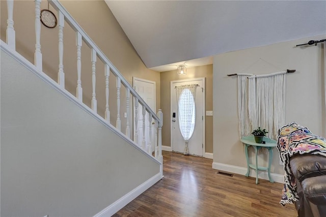 1801 Cash St, Neosho, MO 64850 - entryway featuring visible vents, baseboards, stairway, vaulted ceiling, and wood finished floors