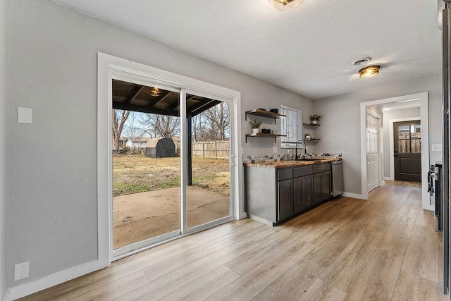 1004 N 30th St, Rogers, AR 72756 - kitchen with dishwasher, light wood-style floors, baseboards, open shelves, and dark brown cabinetry