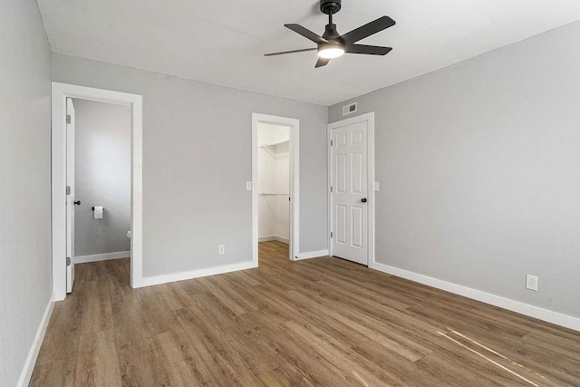 1004 N 30th St, Rogers, AR 72756 - unfurnished bedroom with a spacious closet, wood finished floors, and baseboards