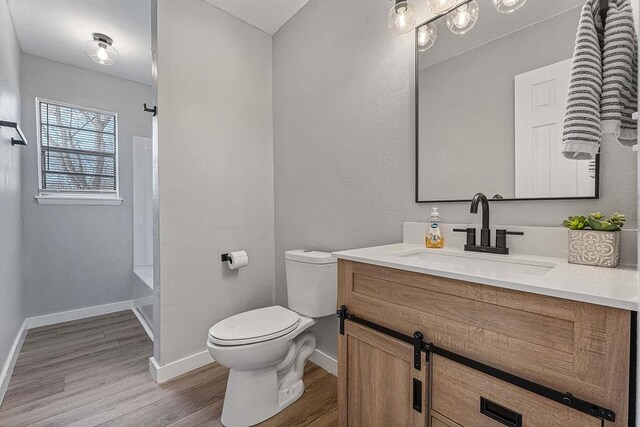 1004 N 30th St, Rogers, AR 72756 - bathroom with toilet, wood finished floors, vanity, and baseboards