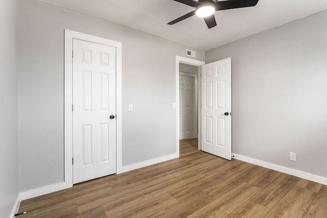 1004 N 30th St, Rogers, AR 72756 - unfurnished bedroom featuring baseboards, light wood-style floors, and ceiling fan