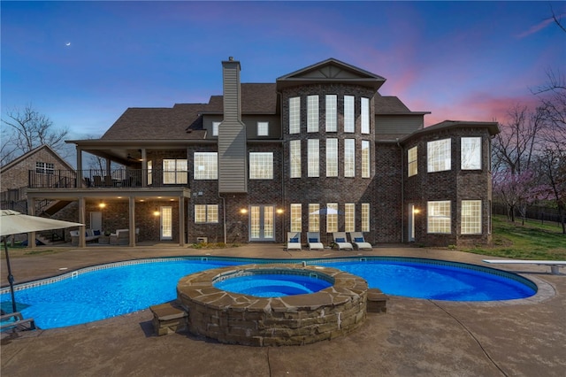 view of pool with a diving board, a pool with connected hot tub, french doors, and a patio area