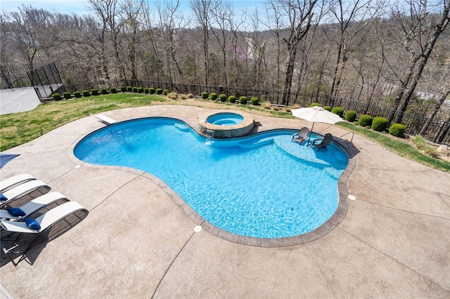 view of swimming pool featuring a fenced backyard, a patio area, a pool with connected hot tub, and a wooded view