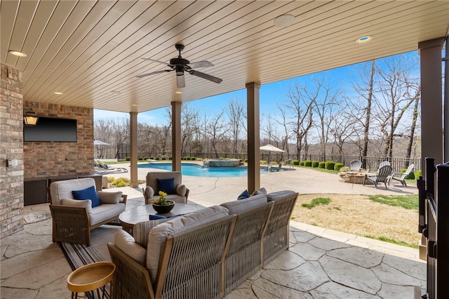 view of patio with a fenced backyard, an outdoor living space with a fire pit, ceiling fan, and an outdoor pool