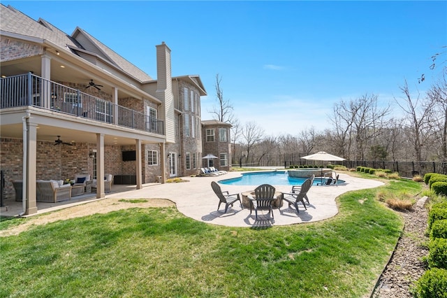 view of swimming pool with a lawn, a ceiling fan, a patio area, and fence