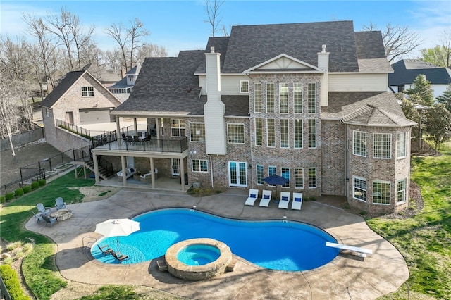 view of pool featuring a patio, a fenced backyard, a diving board, and a pool with connected hot tub