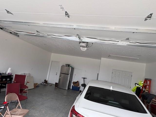 210 Rose Hill Dr, Berryville, AR 72616 - garage featuring a garage door opener and freestanding refrigerator