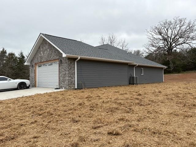 210 Rose Hill Dr, Berryville, AR 72616 - view of side of property with stone siding, concrete driveway, cooling unit, a shingled roof, and a garage