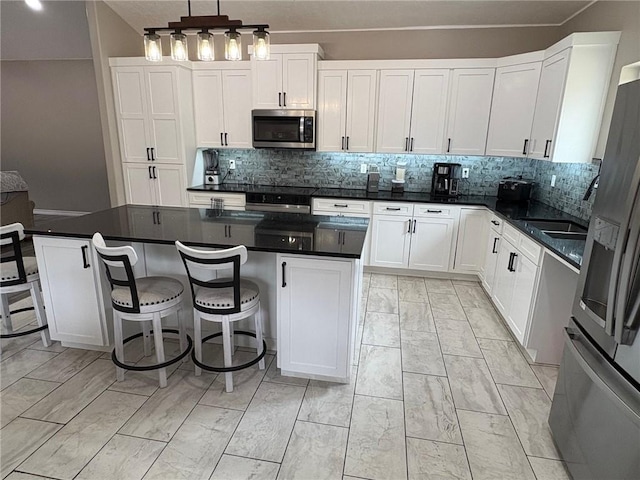 210 Rose Hill Dr, Berryville, AR 72616 - kitchen with white cabinetry, a kitchen island, stainless steel appliances, and decorative backsplash