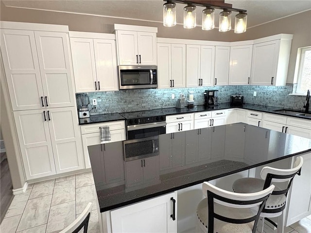 210 Rose Hill Dr, Berryville, AR 72616 - kitchen with oven, stainless steel microwave, white cabinetry, a sink, and a center island