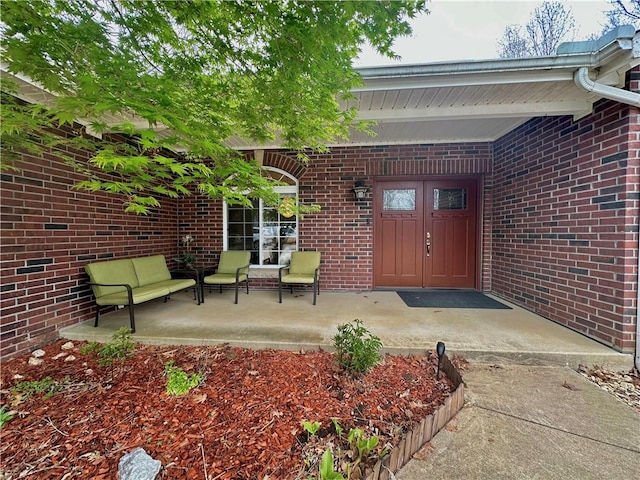 view of exterior entry featuring brick siding