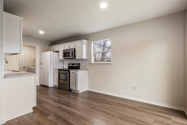 4292 W Beaver Ln, Fayetteville, AR 72704 - kitchen featuring stainless steel appliances, dark wood-style flooring, a textured ceiling, light countertops, and recessed lighting