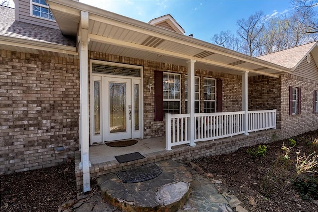 11992 Cripps Rd, Gentry, AR 72734 - entrance to property featuring a shingled roof, a porch, and brick siding