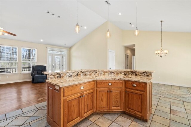 11992 Cripps Rd, Gentry, AR 72734 - kitchen with open floor plan, ceiling fan with notable chandelier, light stone counters, pendant lighting, and light tile patterned floors