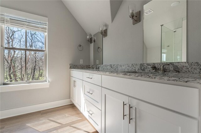 852 S Waxflower Ave, Fayetteville, AR 72701 - bathroom with lofted ceiling, walk in shower, visible vents, double vanity, and wood finished floors