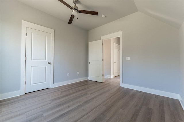 852 S Waxflower Ave, Fayetteville, AR 72701 - unfurnished bedroom featuring baseboards, lofted ceiling, and wood finished floors