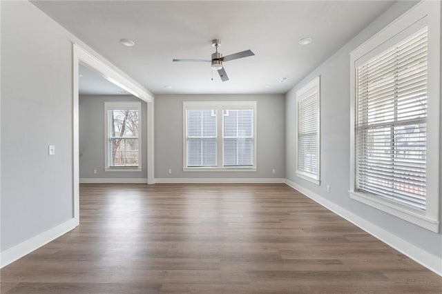 spare room featuring a ceiling fan, baseboards, and wood finished floors