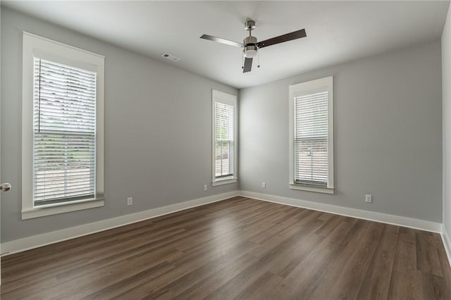 unfurnished room featuring dark wood-type flooring, baseboards, ceiling fan, and visible vents