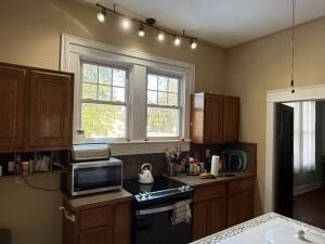 805 N Front St, Dardanelle, AR 72834 - kitchen featuring stainless steel microwave, black electric range, and brown cabinetry