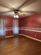 604 S Seattle Ave, Russellville, AR 72801 - unfurnished room with dark wood finished floors, baseboards, and a ceiling fan