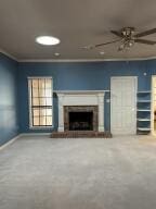 604 S Seattle Ave, Russellville, AR 72801 - unfurnished living room with a fireplace, a ceiling fan, crown molding, and baseboards