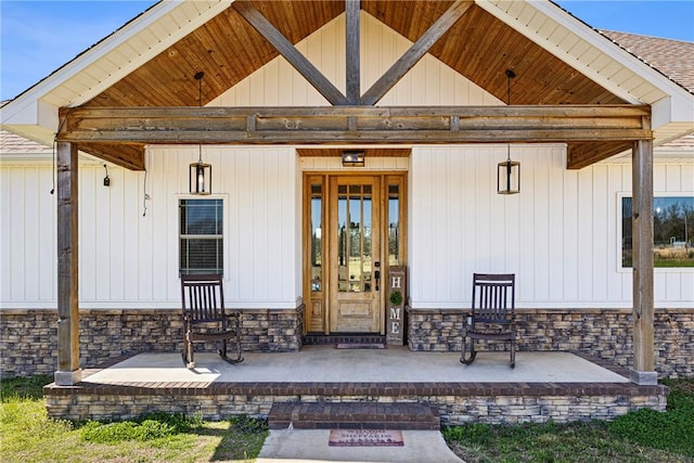 4503 Dogwood Ln, Ozark, AR 72949 - entrance to property with covered porch, stone siding, roof with shingles, and board and batten siding