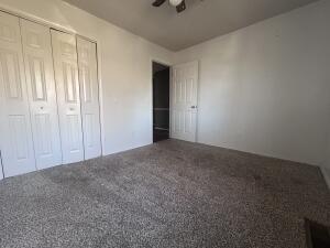 unfurnished bedroom with carpet flooring, a closet, and a ceiling fan