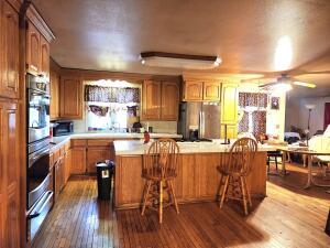 kitchen featuring light countertops, appliances with stainless steel finishes, a ceiling fan, dark wood finished floors, and a warming drawer