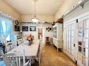 dining area featuring ornamental molding, french doors, and tile patterned floors