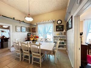 dining area with tile patterned floors, crown molding, and wainscoting