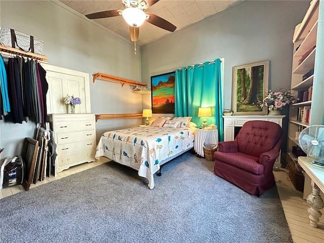 bedroom with ornamental molding, ceiling fan, and wood finished floors