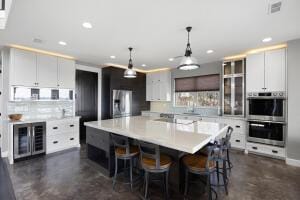 1053 Tucker Mountain Rd, Dover, AR 72837 - kitchen featuring wine cooler, light countertops, double oven, and a kitchen breakfast bar