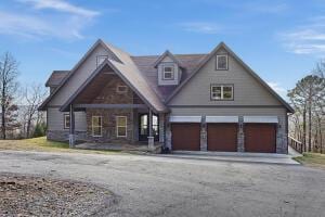 1053 Tucker Mountain Rd, Dover, AR 72837 - view of front facade with aphalt driveway, an attached garage, and covered porch