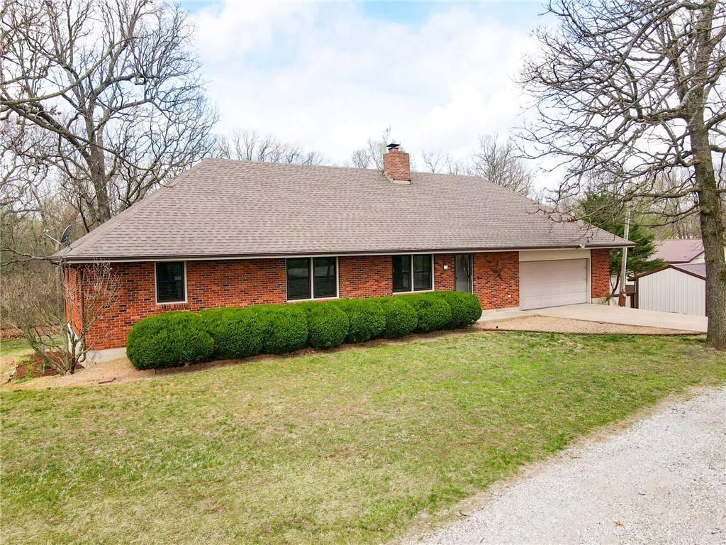 21247 State Highway 97, Pierce City, MO 65723 - single story home with brick siding, driveway, a garage, and a front lawn