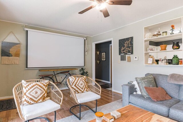 cinema featuring built in features, baseboards, ceiling fan, and wood finished floors
