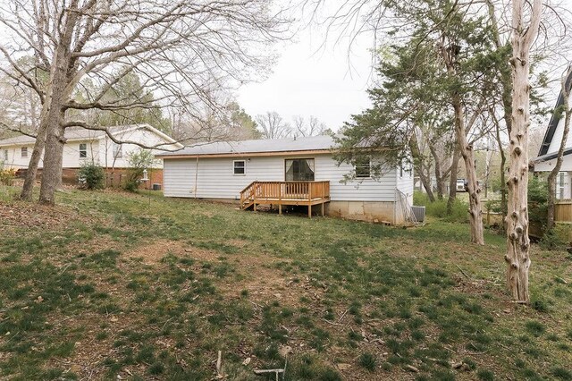 rear view of house with crawl space, a yard, and a wooden deck