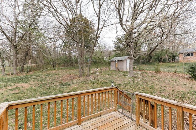 wooden terrace featuring an outbuilding and a shed