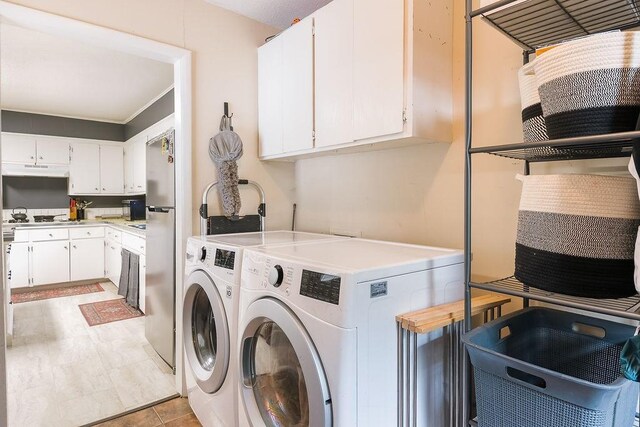 clothes washing area featuring washing machine and clothes dryer and cabinet space