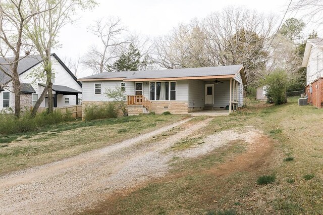 view of front facade featuring an attached carport, driveway, central AC, and fence